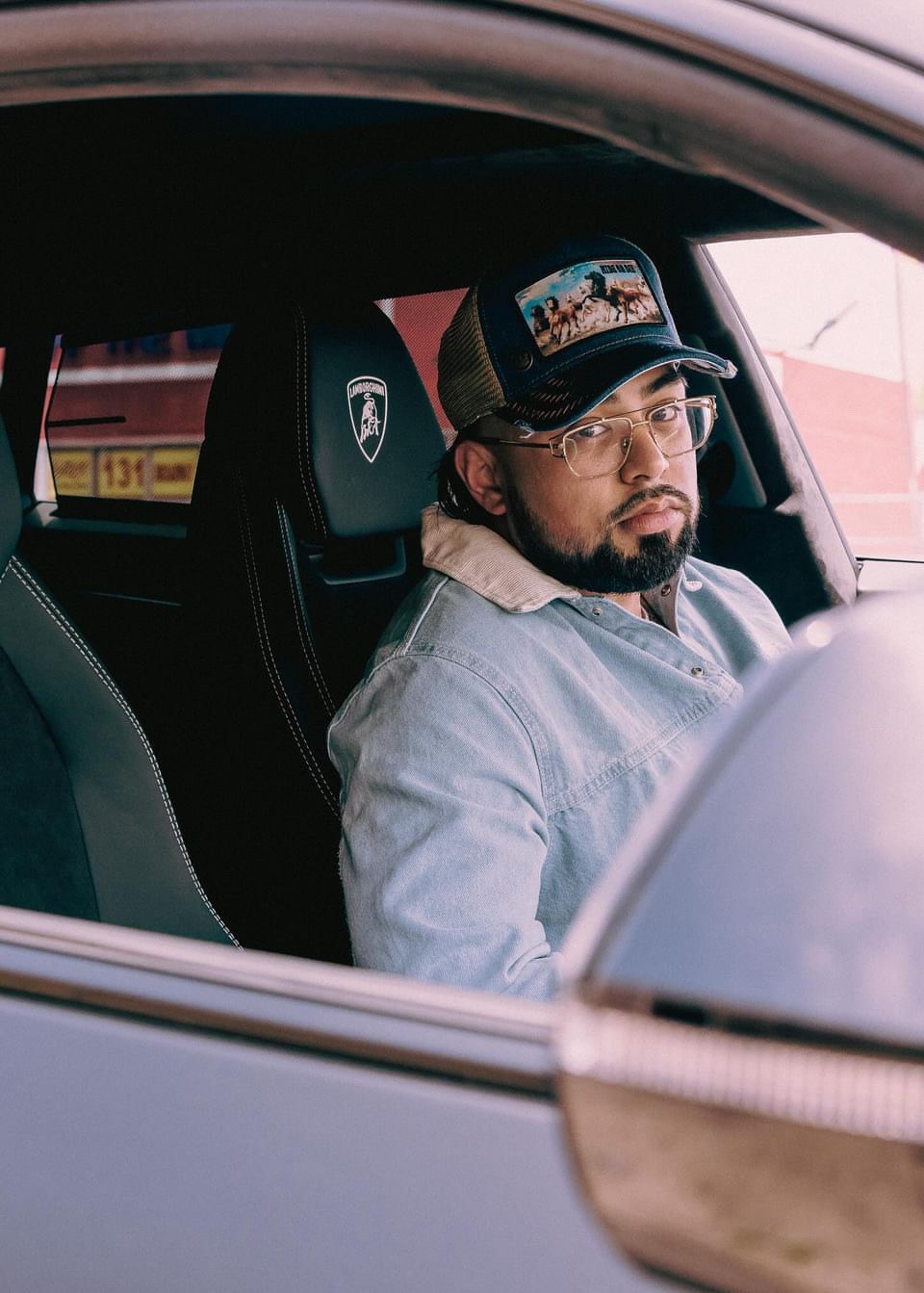 Coach P at 220 pounds, seated in his Lamborghini, viewed through the open window